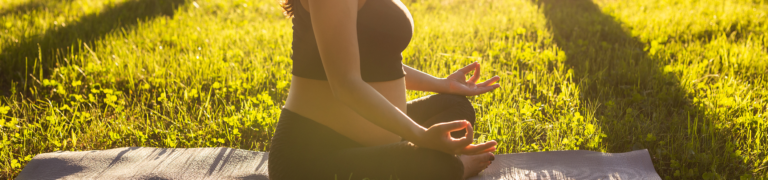 Schwangere meditiert im Park.